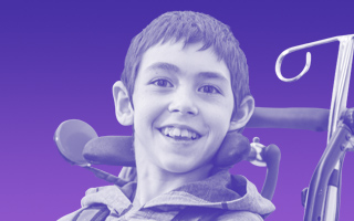 secondary-kid-5 Image of a teenage boy smiling in a wheelchair